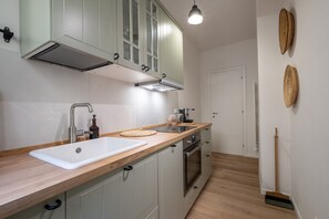 Eine moderne Küche mit einer weißen Spüle, einem Edelstahlarmaturen und einem eingebauten Backofen.