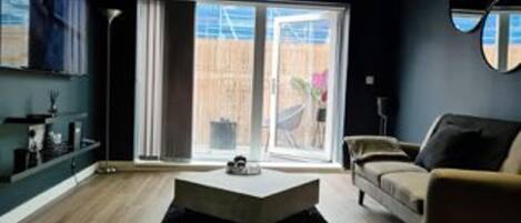 Ein modernes Wohnzimmer mit einer Couch, einem Couchtisch und einem großen Fenster.
