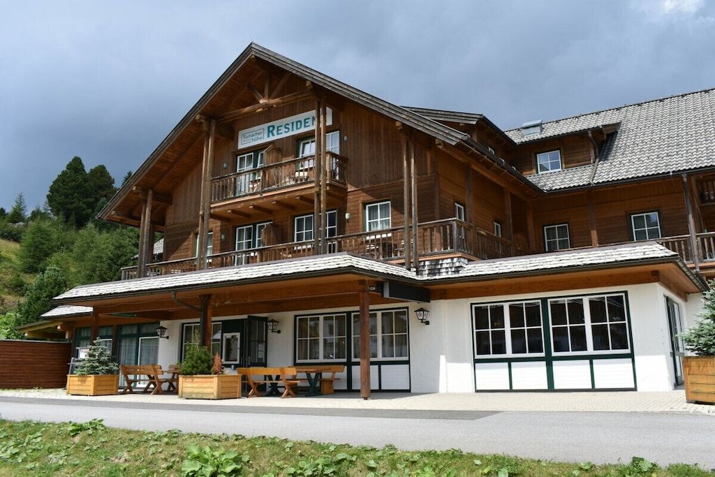 Un grand bâtiment en bois sur lequel on peut lire l’inscription « RÉSIDENCE ».