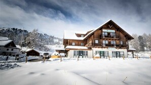 Un lodge in legno con un'area reception, diverse finestre e un cartello che indica 'RESIDENZ'.