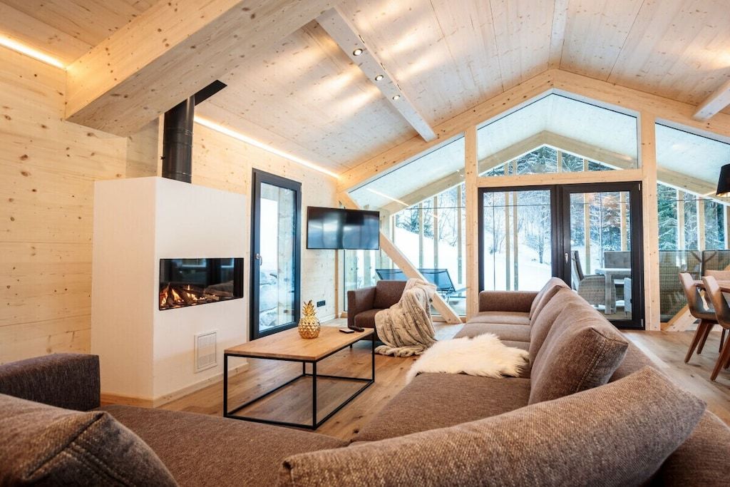 Una sala de estar acogedora con chimenea, asientos cómodos y ventanas amplias.