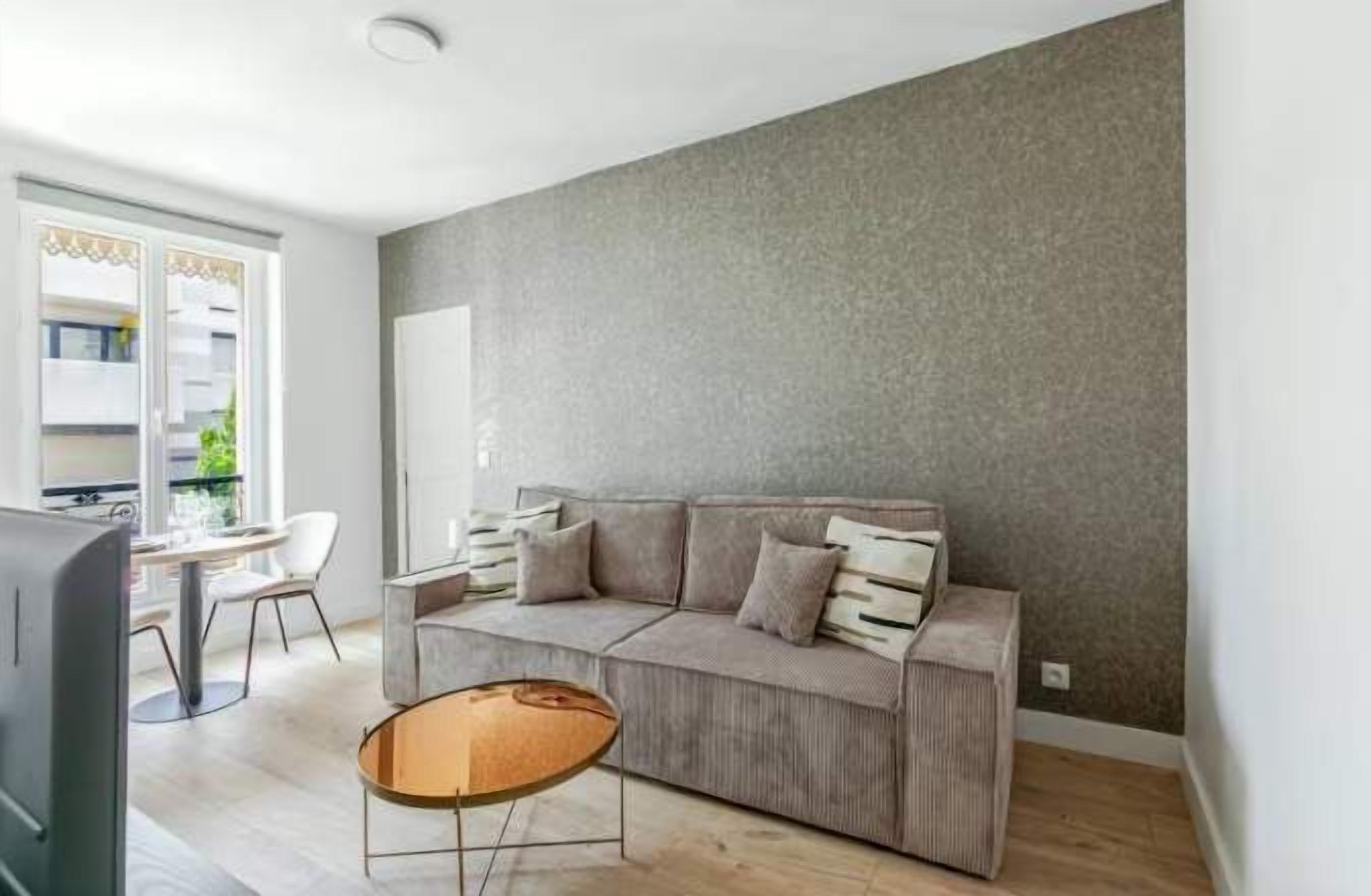 Un salon avec un canapé, une table basse et un téléviseur.