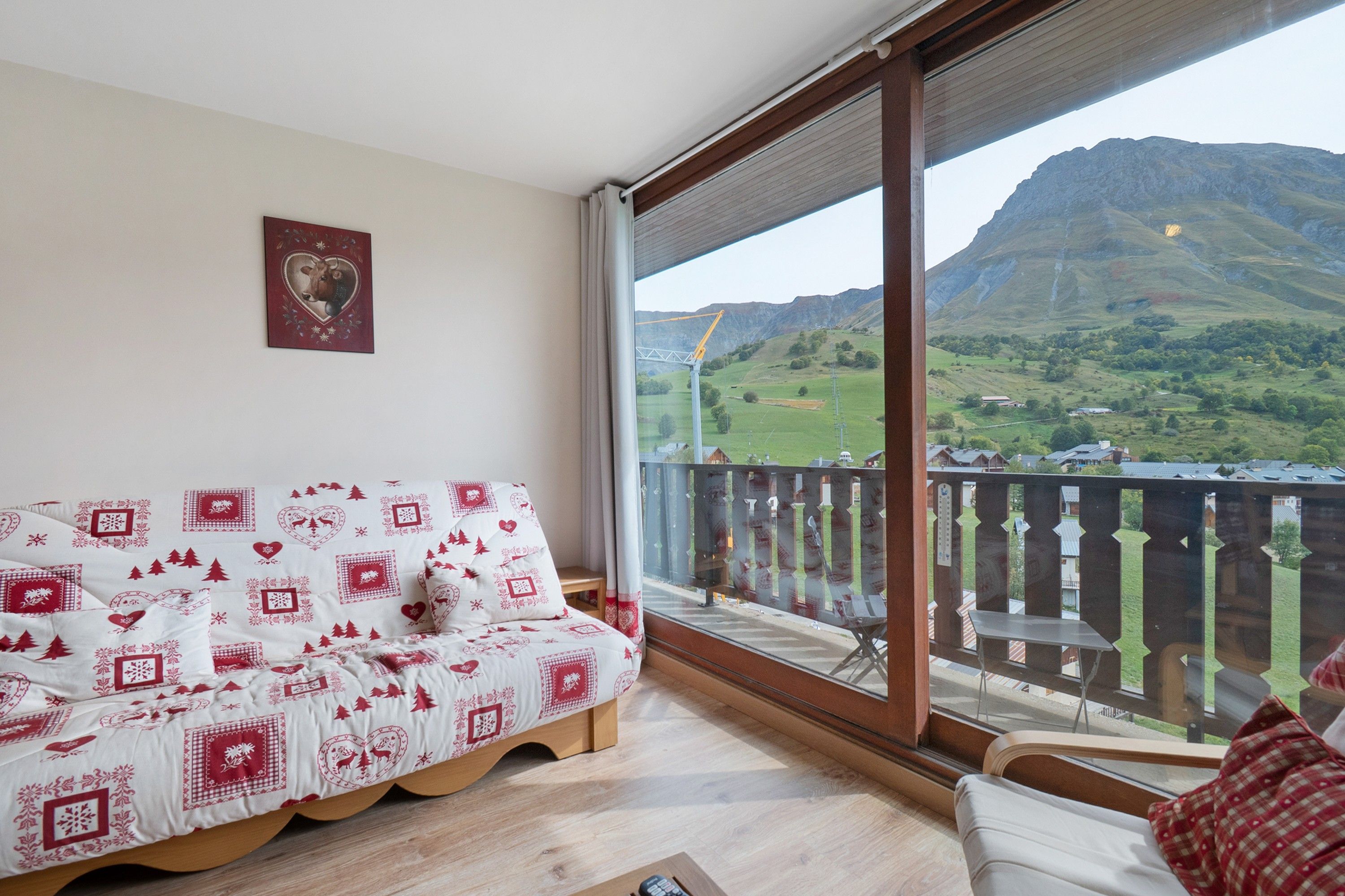 Una habitación con sofá y vistas a un paisaje montañoso a través de un ventanal grande.