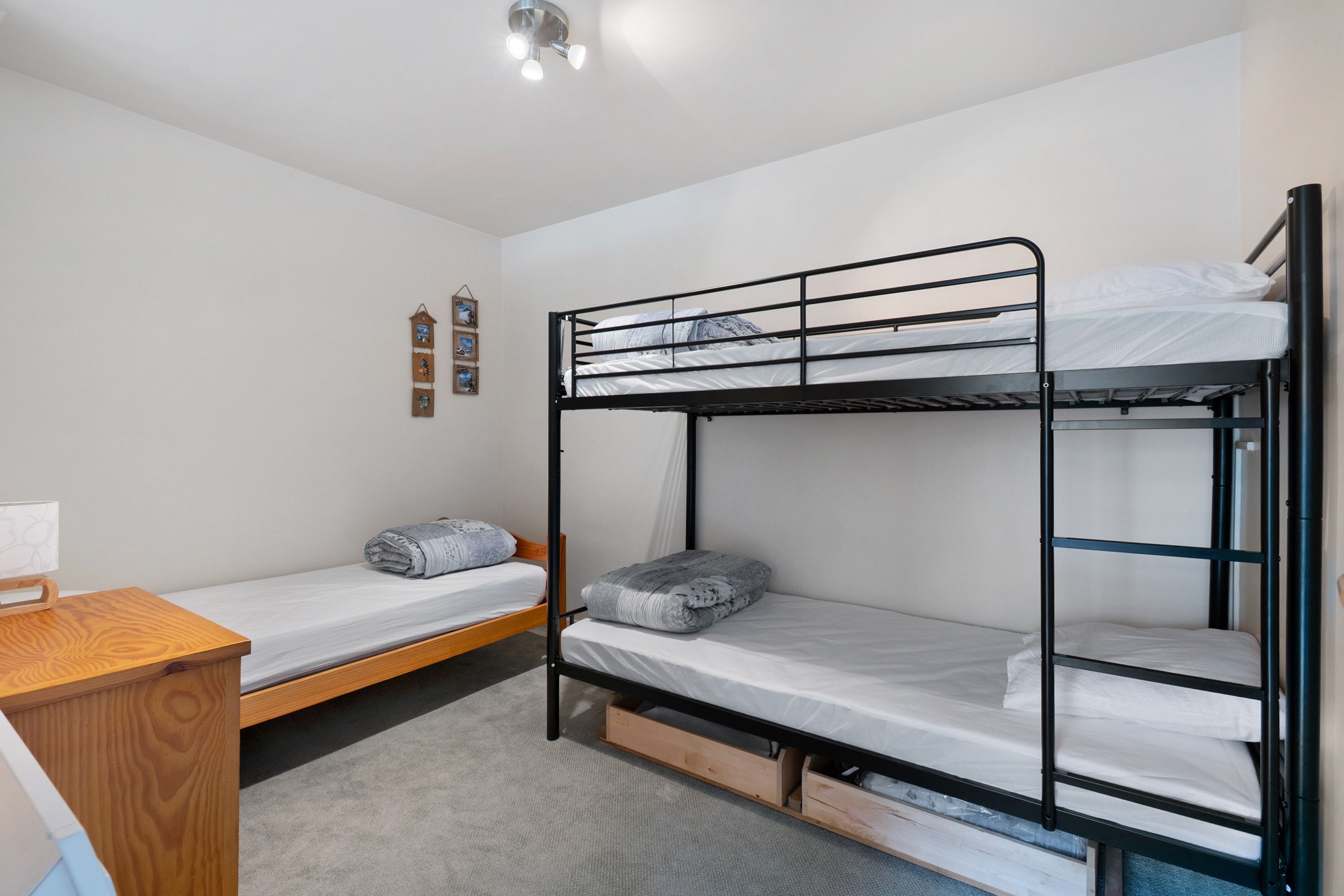 Une chambre avec un lit superposé, un bureau et une horloge au mur.