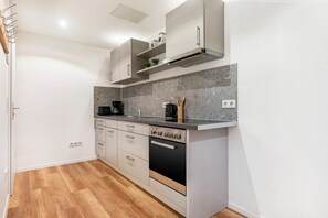Uma cozinha moderna com forno embutido, máquina de café e pia.