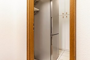 Une salle de bain avec une porte blanche, un miroir et un porte-serviettes.