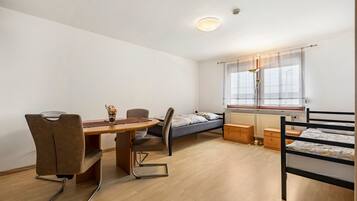 Ein kleines Zimmer mit Bett, Schreibtisch und Stuhl.