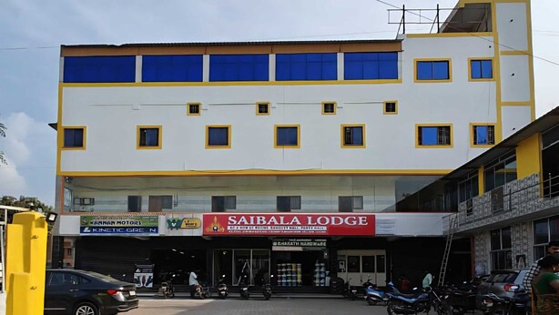 A multi-story building with a ground-level commercial space featuring a prominent red sign for 'SAIBALA LODGE'. - Hotel O Vellore Formerly SP Highway Inn (Vellore)