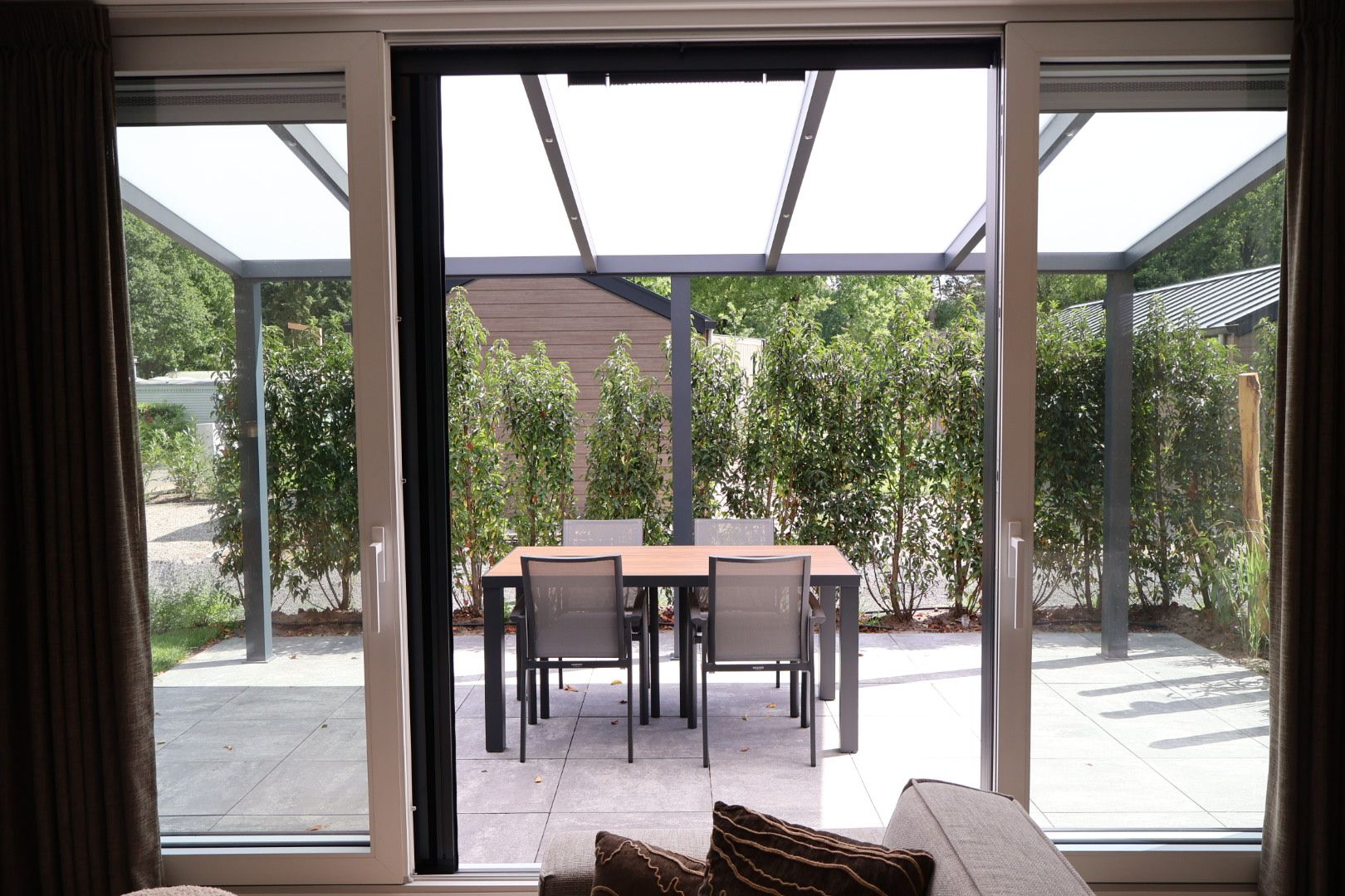 Een moderne kamer met een schuifglazen deur die uitkomt op een terras.