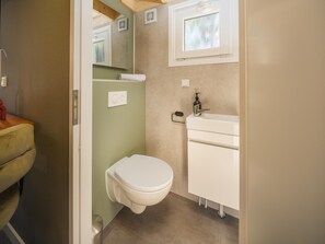 Ein kleines Badezimmer mit Toilette, Waschbecken und Spiegel.
