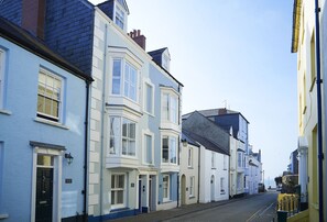 Eine schmale Straße gesäumt von traditionellen Gebäuden, darunter Erker und eine Mischung verschiedener Baustile.