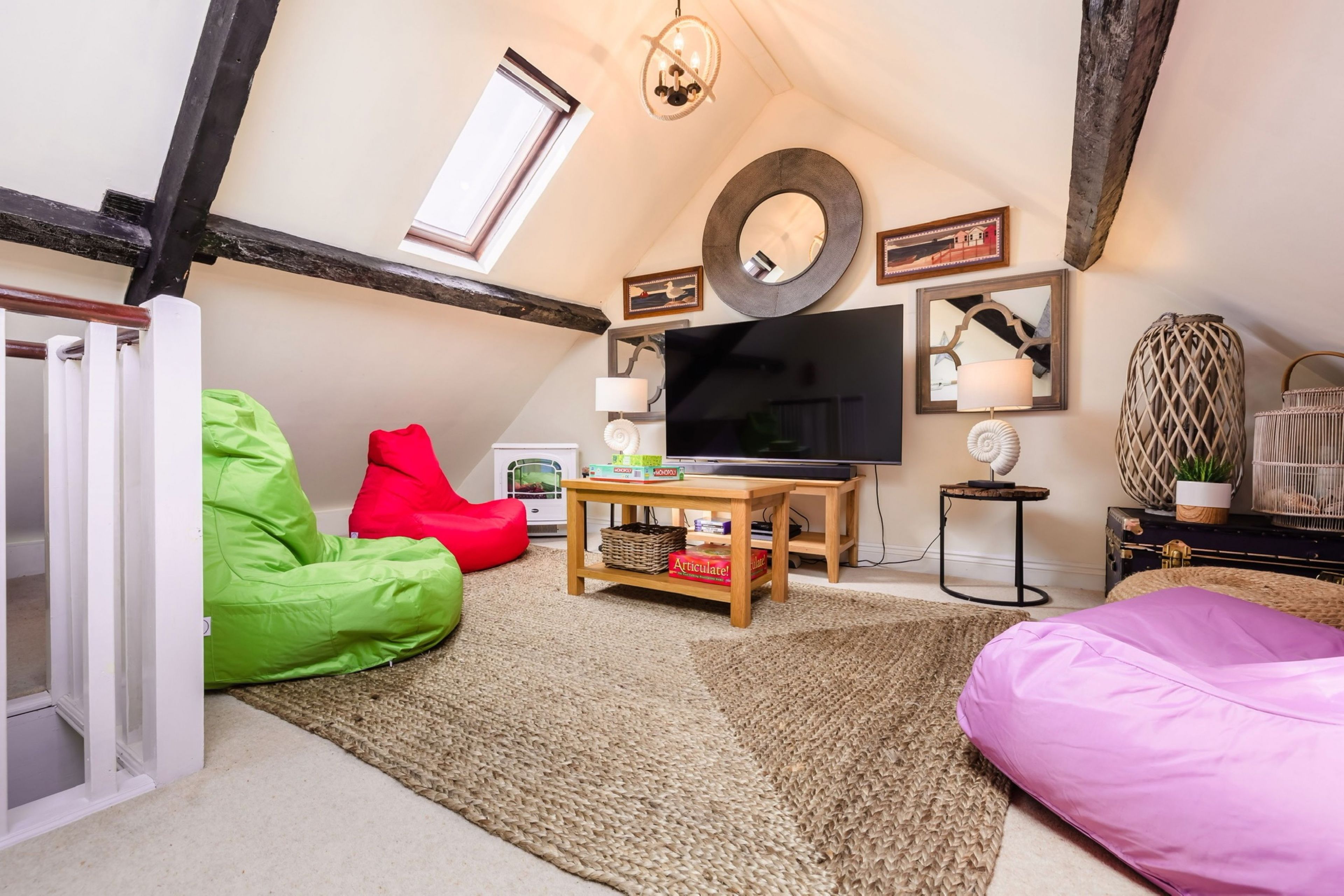 Ein gemütliches Wohnzimmer mit Fernseher, Sitzsäcken und Kamin.