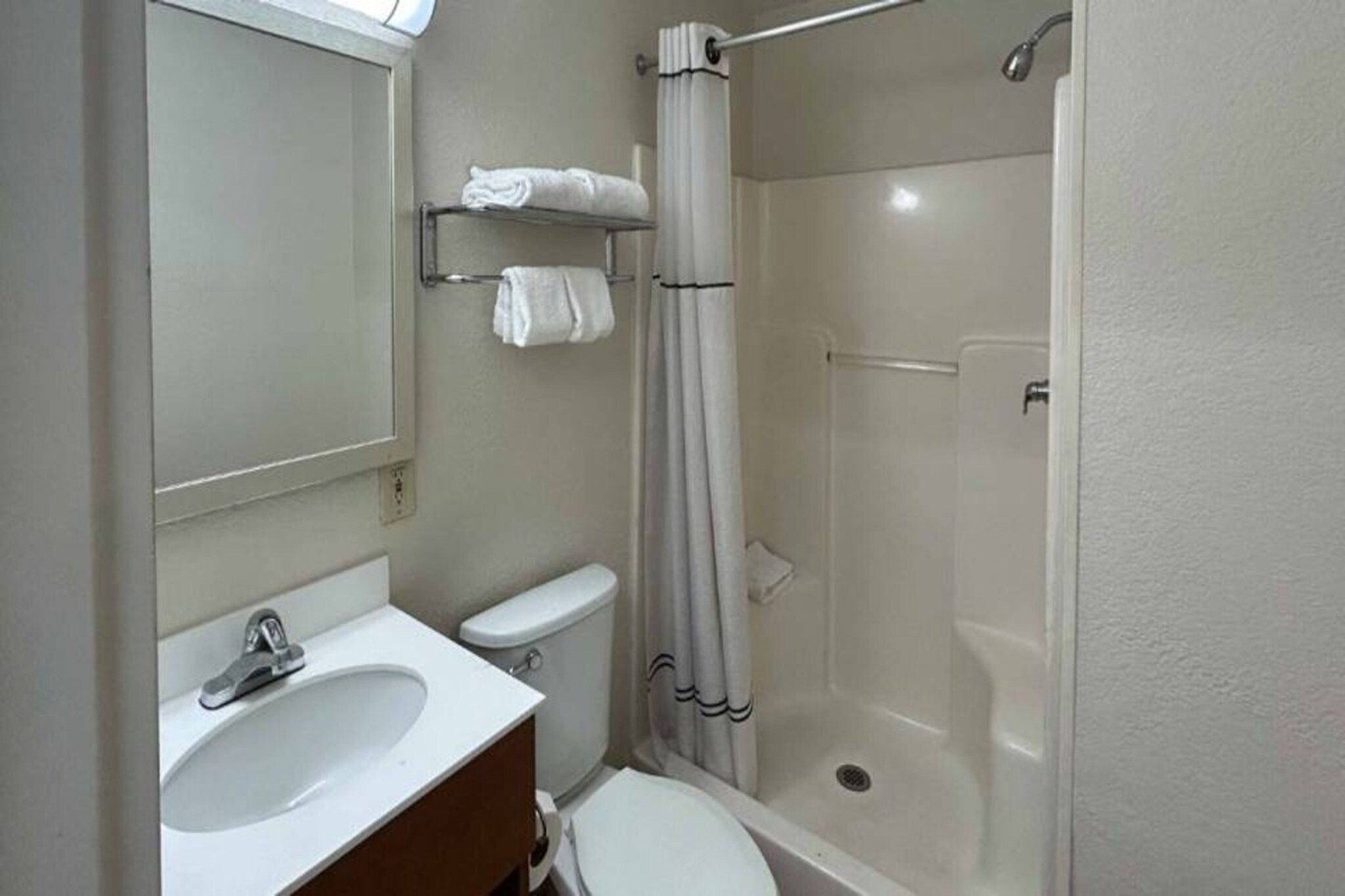 Un baño con inodoro, lavamanos y ducha.