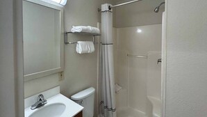 Un baño con inodoro, lavamanos y ducha.