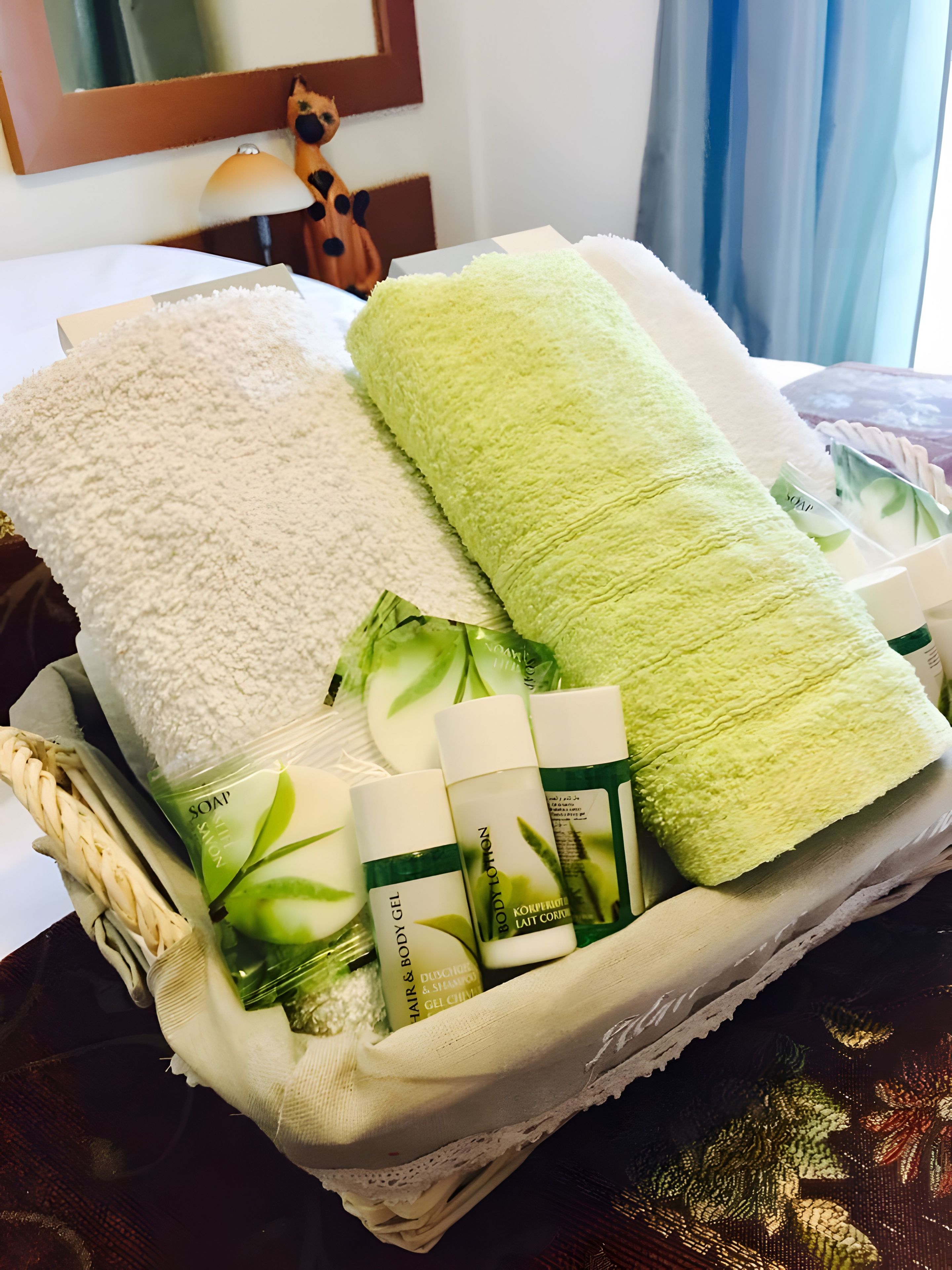 A basket containing towels, a bottle of shampoo, and a bottle of lotion.