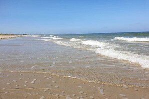 A beach with waves gently lapping at the shore. - Holiday paradise sea air (Kamperland)