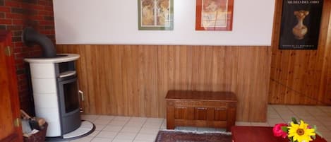 Ein Zimmer mit einer holzgetäfelten Wand, einem Kamin, einer Bank, einem Teppich und einem Poster des Museo del Oro.