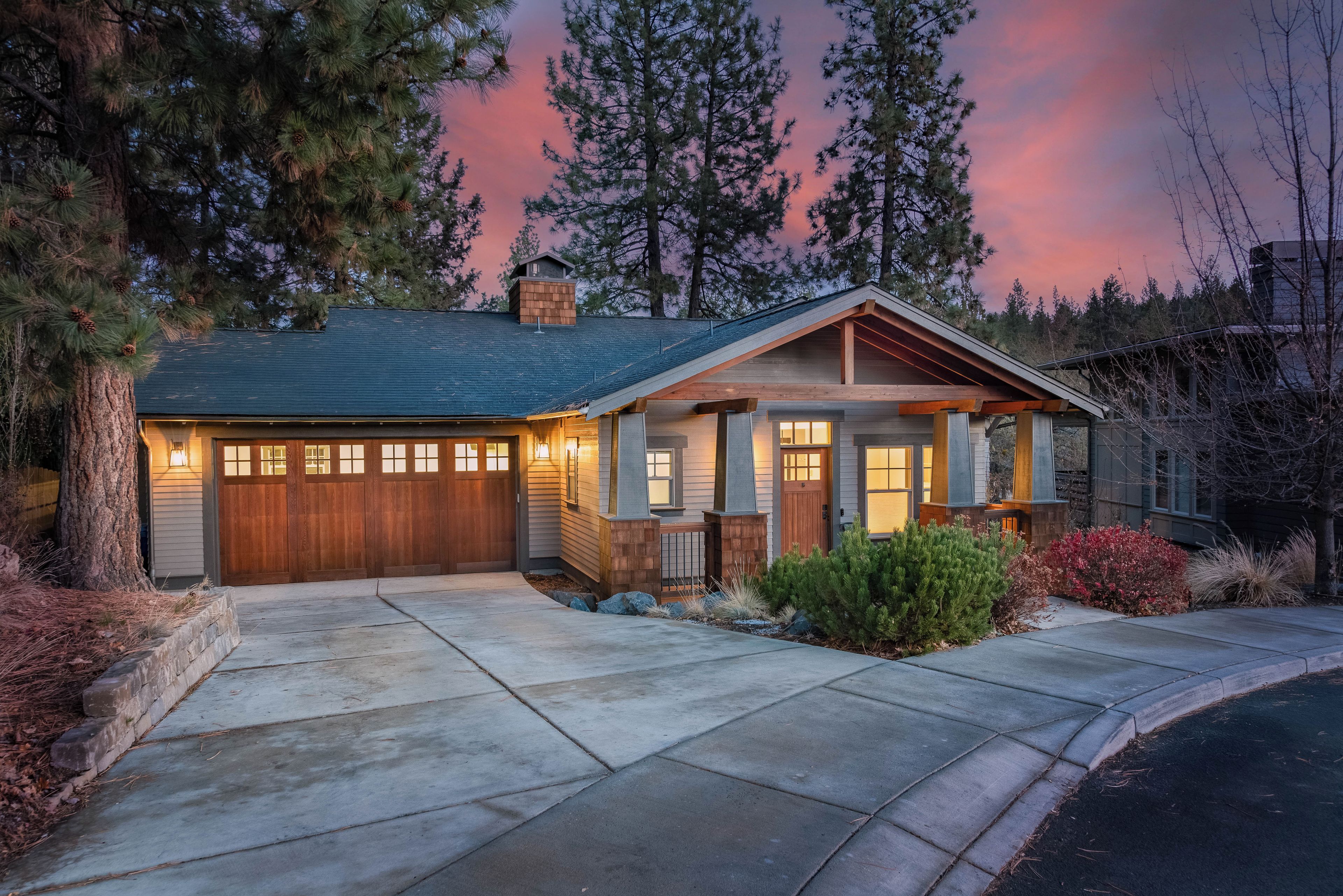 A two-story house with a garage, a front porch, and a landscaped front yard.