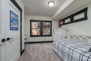 Ein Schlafzimmer mit einem Bett, einem Schreibtisch und einem Fenster.