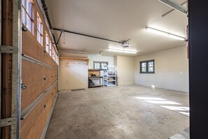 Eine geräumige Garage mit Betonboden, Holzschränken und einer Lochwand.