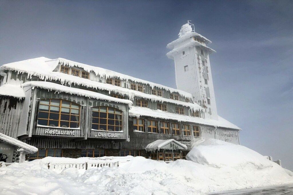A building with a restaurant and guest rooms, surrounded by snow.