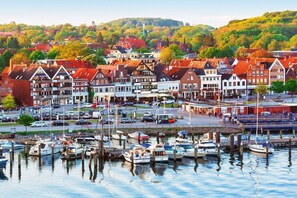 Un port de plaisance où sont amarrés des bateaux, entouré de bâtiments de style européen traditionnel.