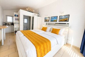 Ein Hotelzimmer mit Bett, Schreibtisch und einer Küchenzeile.