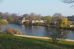 Vista fluvial amb un parc, un edifici amb cúpula verda i un camí.