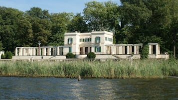 A waterfront property with a large building, a dock, and a river.