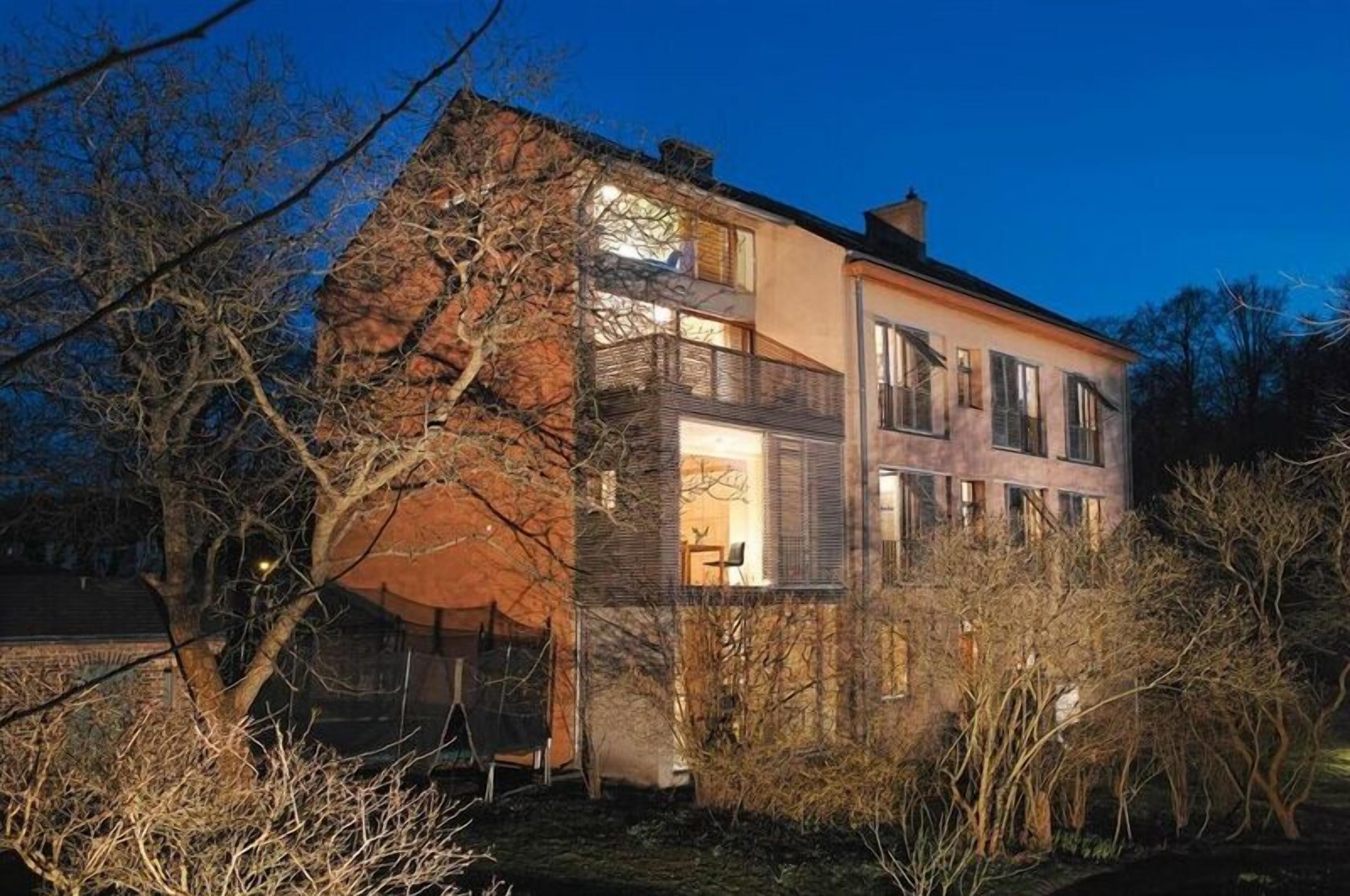 A two-story building with a brick facade and a large window on the upper floor.