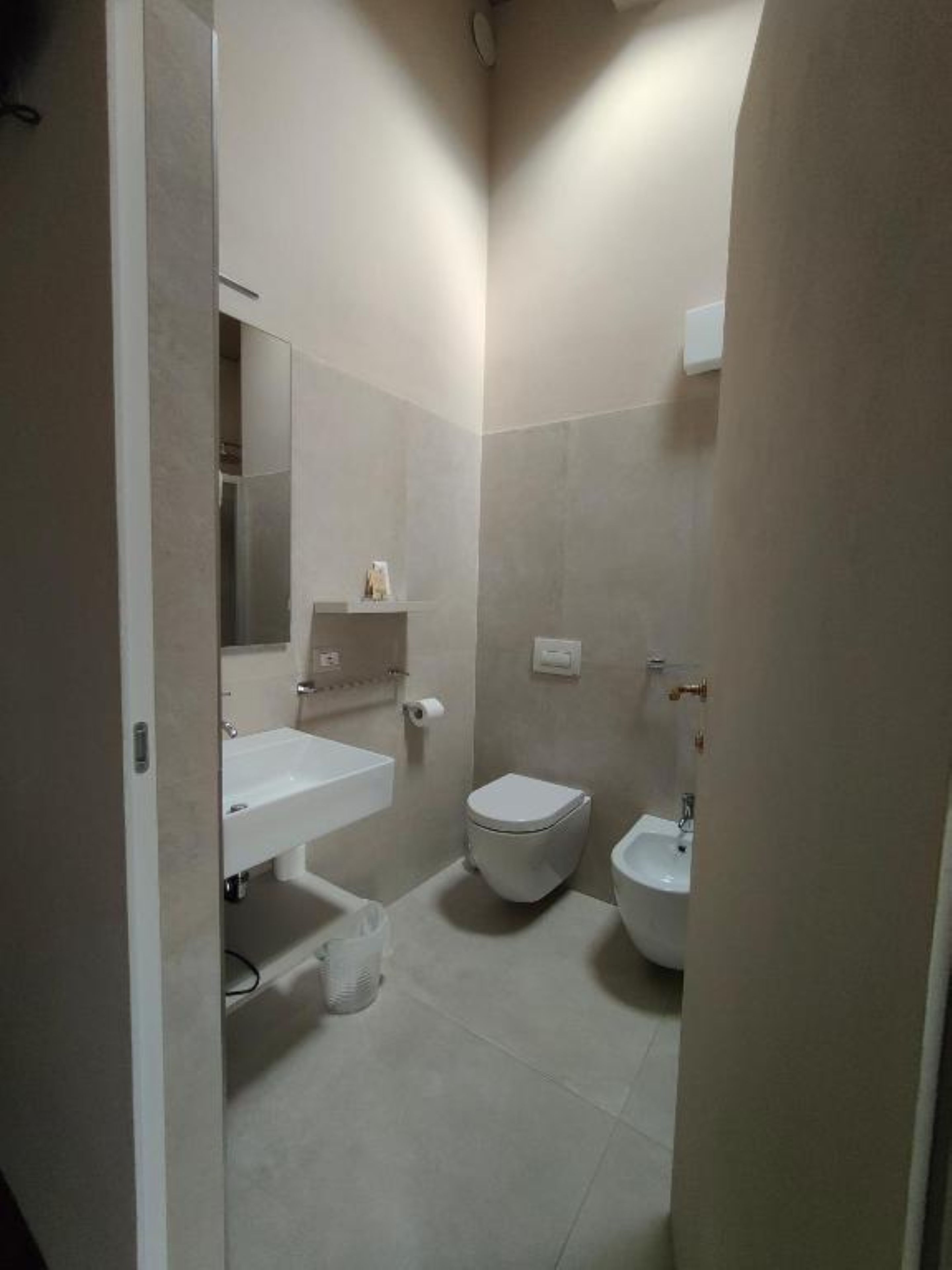 A bathroom with a toilet, bidet, and sink.