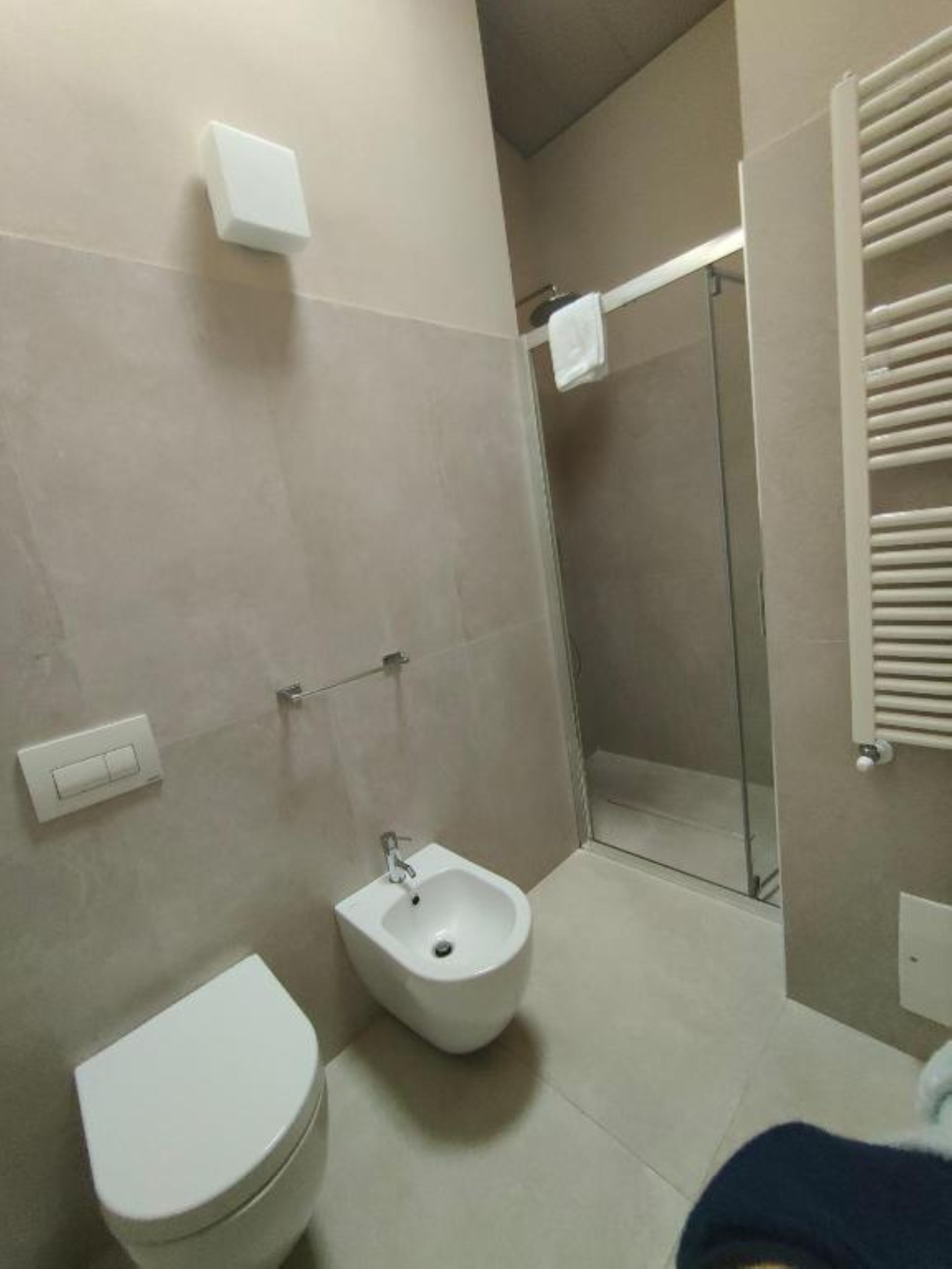 Un baño con inodoro, bidé y ducha con mampara de vidrio.