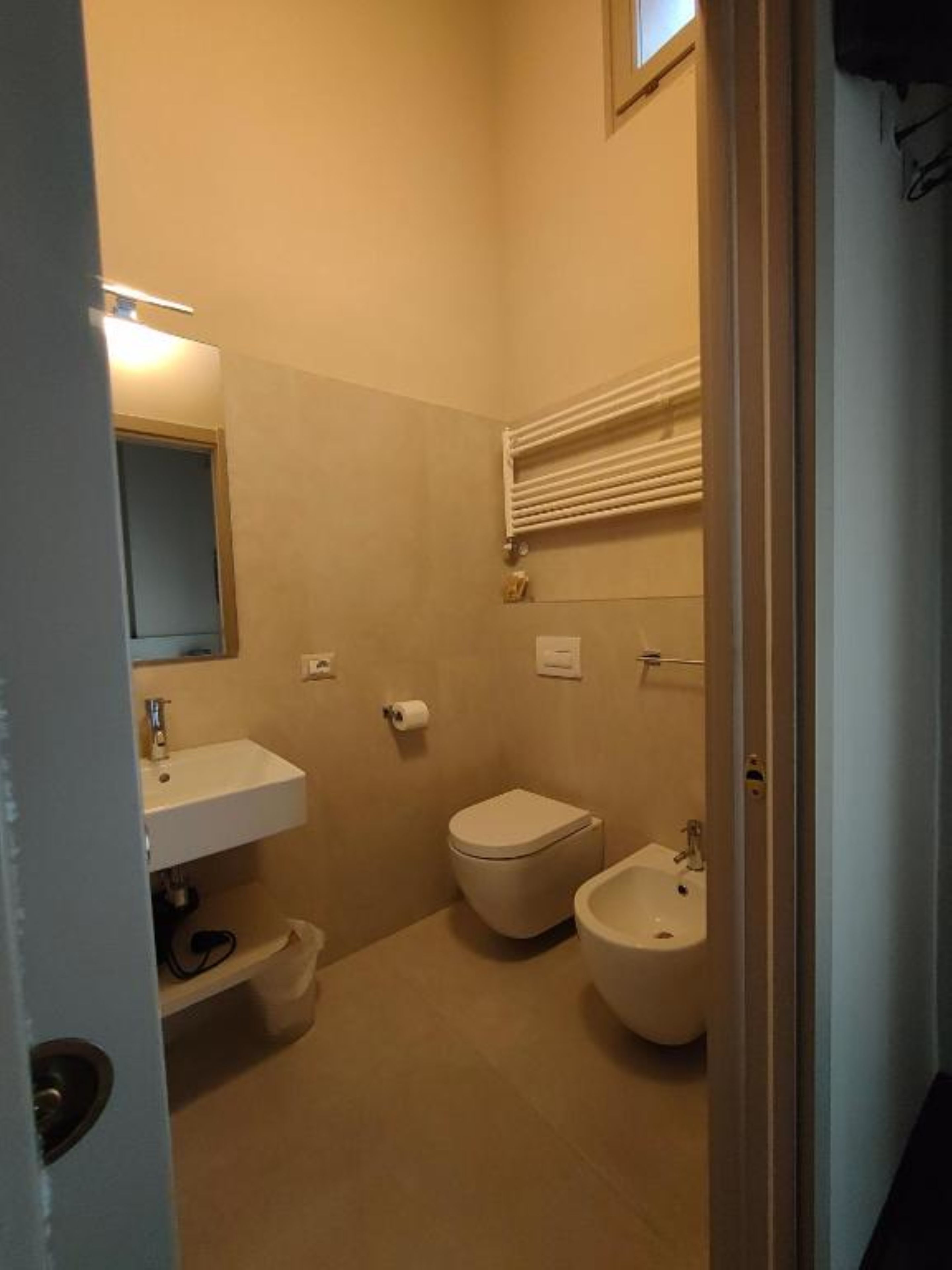 A small bathroom with a toilet, bidet, and sink.
