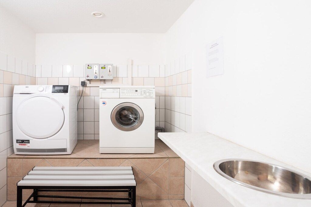 A laundry room with a washing machine, dryer, and a sink.