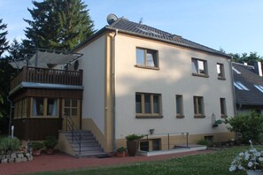 A two-story building with a balcony, a staircase, and potted plants. - Eldenholz on the Reeck Canal (Waren)