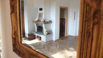 A room with a fireplace, a mirror, and a herringbone floor pattern.