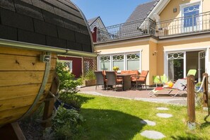 A residential property with a patio, outdoor seating, and a wooden barrel. - Holiday home in Zingst with swimming pool (Zingst)