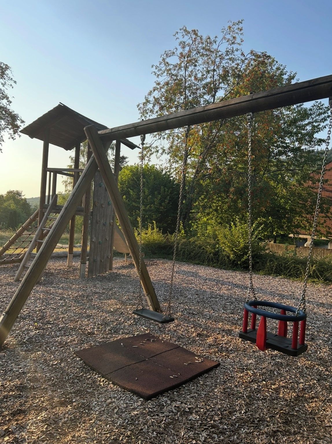 A playground with a swing set and a climbing structure.