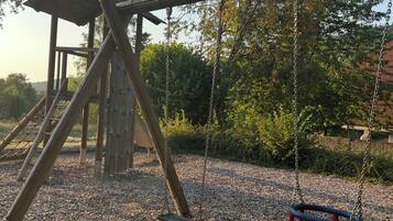 A playground with a swing set and a climbing structure.