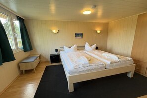 A bedroom with a double bed, bedside tables, a bench, and two wall-mounted lamps. - Bungalow in Koserow with swimming pool (Koserow)