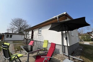 A patio with outdoor furniture and a large umbrella. - Bungalow in Koserow with swimming pool (Koserow)