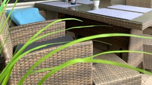 A balcony with wicker furniture, a glass table, and a view of the sky. - Apartment 'Harz 21' with Dreamy Balcony Views (Braunlage)