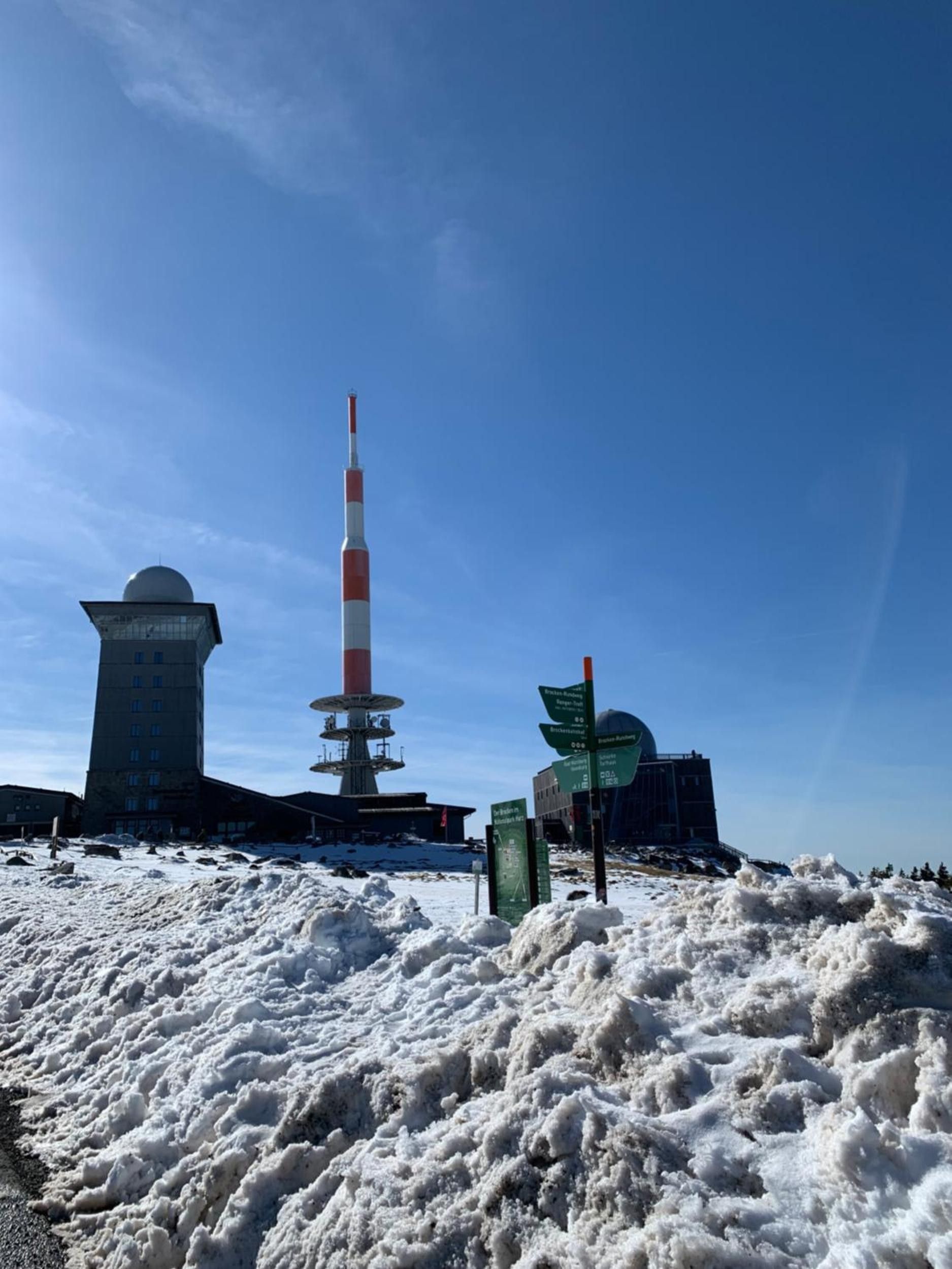 Eine verschneite Landschaft mit einem hohen Turm und einem Gebäude mit einer Kuppel.