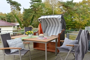 Eine Terrasse im Freien mit Tisch, Stühlen und einer überdachten Sitzecke.