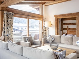 Una habitación acogedora con sofá, sillones, una mesita de centro y una lámpara.