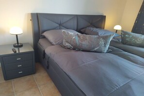 A bedroom with a bed, nightstands, and lamps. - Holiday home with 1 bedroom (Bad Zwischenahn)