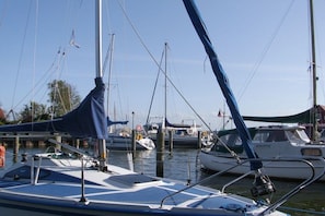 A marina with multiple boats docked, featuring masts and sails, and a clear sky. - Holiday apartment Hehl (Born)