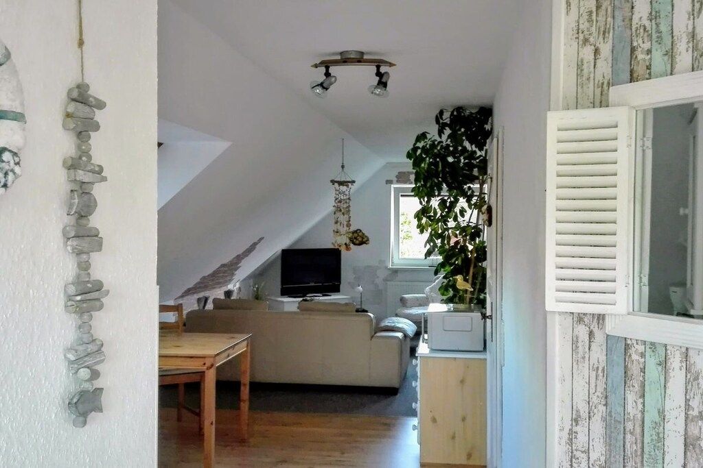 A cozy living area with a sofa, a television, and a dining table.