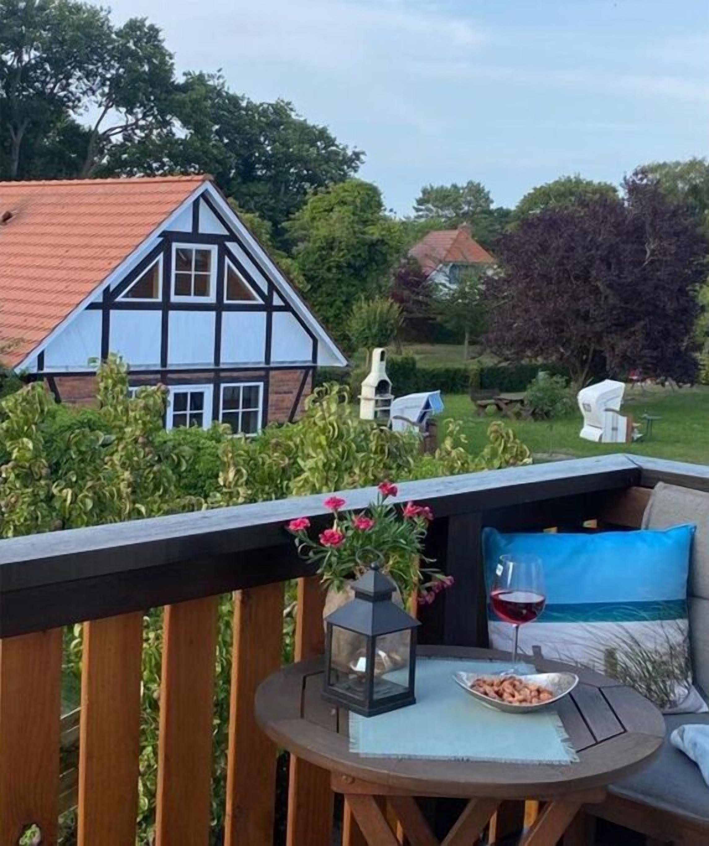 Une terrasse avec une table ronde, une lanterne et un bol rempli de collations.