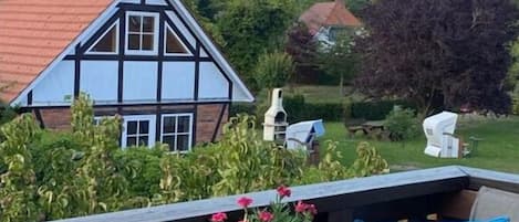 Eine Terrasse mit einem runden Tisch, einer Laterne und einer Schüssel mit Snacks.